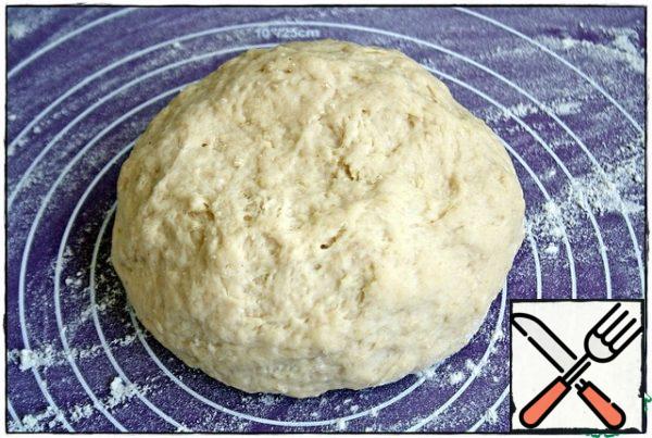 After ten minutes, put the dough on the work surface, dusted with flour and roll out into a rectangular layer measuring thirty by forty centimeters. If the rolling pin will stick to the dough, then the dough is also slightly dusted with flour, just a little- do not overdo it.