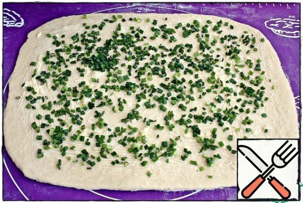Then grease the dough with garlic oil, sprinkle with chopped green onions. Instead of onions, you can take a bunch of parsley or dill.
