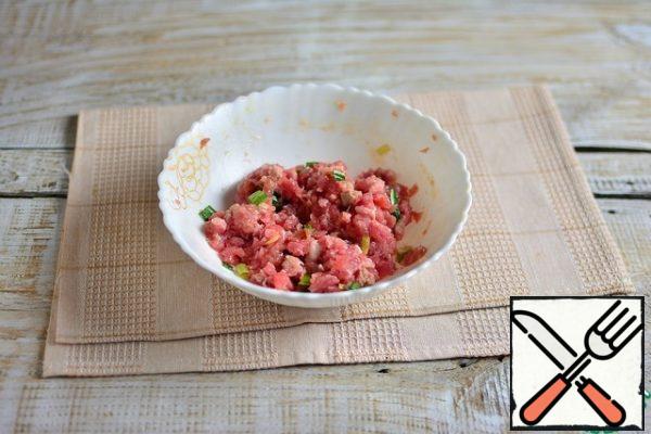 Cut off excess fat from the lamb, turn it in a meat grinder with a large grate, add garlic through a press (1 clove), egg, chopped green onions, egg, spices for lamb and salt to taste. Stir.