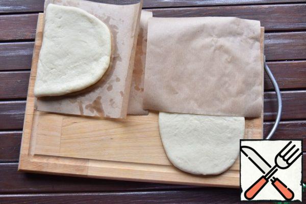 Put the paper blank on half of the dough and roll the tortilla in half, covering the paper on top.