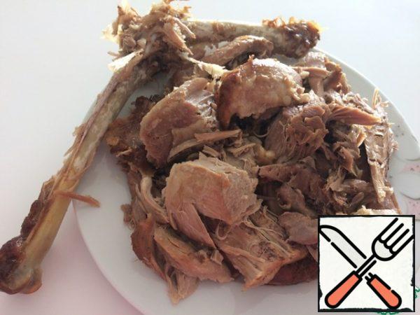 Using two forks, remove the meat from the bone.