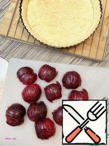 Wash the plums, dry them, cut them in half and remove the stone. Cut each half into slices with a sharp knife so that the halves retain their shape.