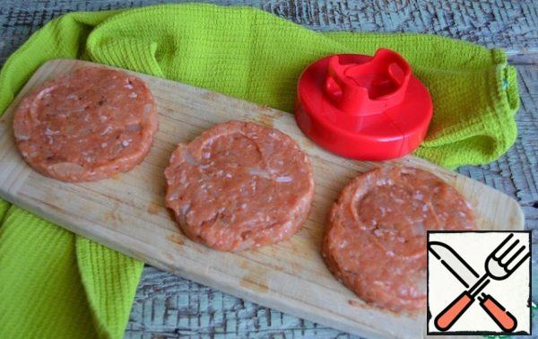 Beat off the minced meat, form three flat cutlets, slightly larger than the diameter of the buns.