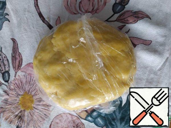 Knead the dough with your hands in a lump, if it crumbles a lot - moisten your hands. We form a ball, wrap it in film, and put it in the refrigerator for half an hour.
