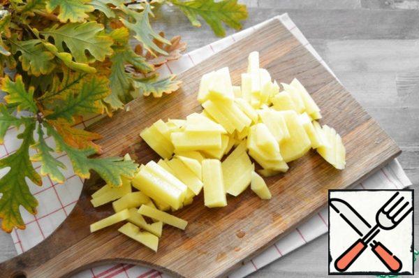 Peel the potatoes and cut them into cubes.