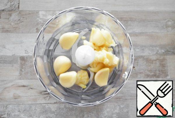 In the bowl of a blender put the pulp of roasted garlic and raw garlic.