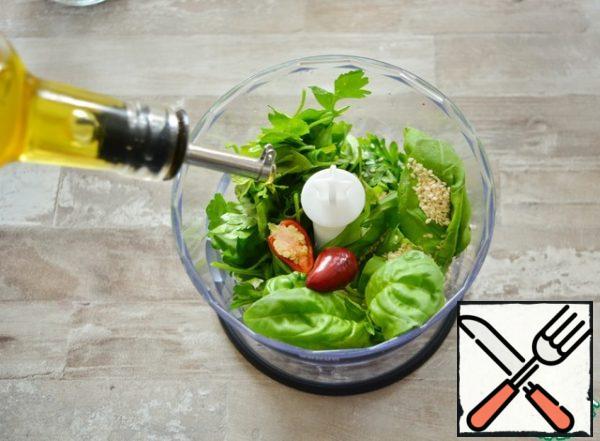 Add the Basil, parsley, sesame seeds and fresh hot pepper.

I have a very small pod, about 2 cm long, but it is very sharp. You can use hot pepper to taste. You can also take a green pepper.

Pour in the unrefined sunflower oil and add salt.