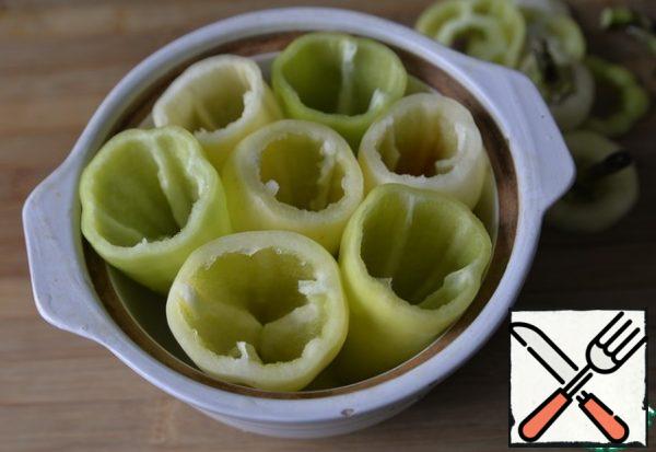 We cut off the stalks of pepper and clean them.
This dish can be prepared both on the stove and in the oven. For the stove, it is convenient to take a large saucepan or cauldron. For the oven any form. I have a round, high, ceramic one with a lid. I cooked in the oven.