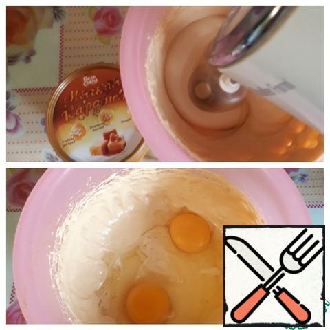 Beat the butter ( or margarine, spread) with the caramel and boiled condensed milk with a mixer for about two minutes. Add the eggs and mix well. If you do not have caramel, take only boiled condensed milk (250 g).