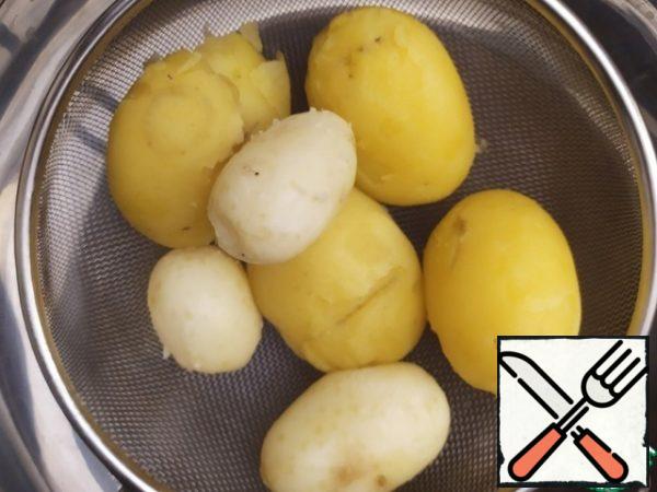 Boil the potatoes with 1 tablespoon of salt. Let's salt the water, cool it, and clean it.