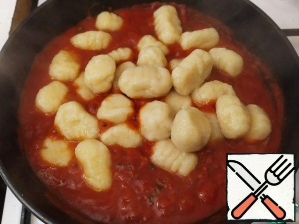 When the gnocchi are ready, transfer them to the sauce and mix well. If the sauce is too thick, add a little water from the gnocchi.