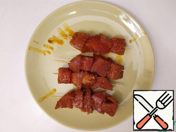 Firmly press the tuna onto the skewers.
