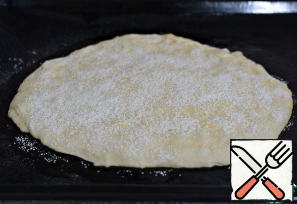 And use the same spatula to spread the dough on the baking sheet, forming a tortilla about 1 cm thick. Sprinkle the formed tortilla with a small amount of flour. Cover the tortilla with a thin towel or napkin (that's why you had to sprinkle the tortilla with flour, so that the fabric does not stick to the dough during proofing) Put the pan with the tortilla in the heat for 15-20 minutes. Do the same with the remaining half of the test.