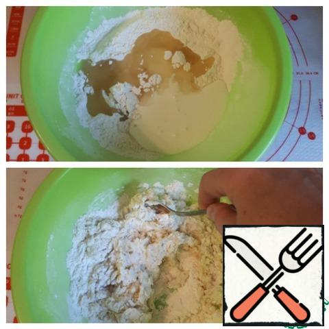 Prepare the dough. In the flour, pre-sifted, add salt, sugar, baking powder, kefir and vegetable oil, mix everything well and knead the dough.