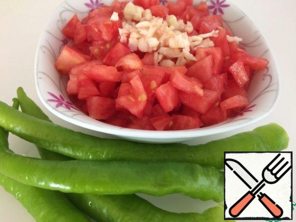 While the eggplant gets rid of bitterness, we clean the peppers from the tails and seeds, garlic - from the husk, tomatoes from the skin. Cut tomatoes into 0.5 cm cubes, garlic - small plates.