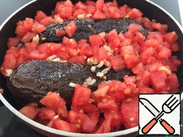 Put our eggplant and pepper in the pan (you can use the one where the vegetables were fried, if the oil is not burned out), top with tomatoes and garlic, salt.