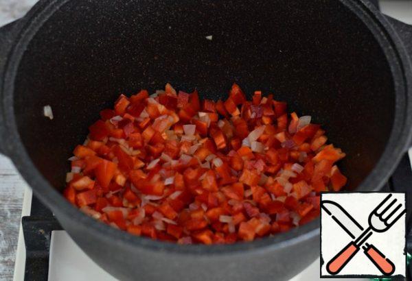 Cut the bell pepper into a slightly larger cube than the onion. Pour it into the pan with the onion, stir and simmer the vegetables under the lid for 5-7 minutes, stirring occasionally.