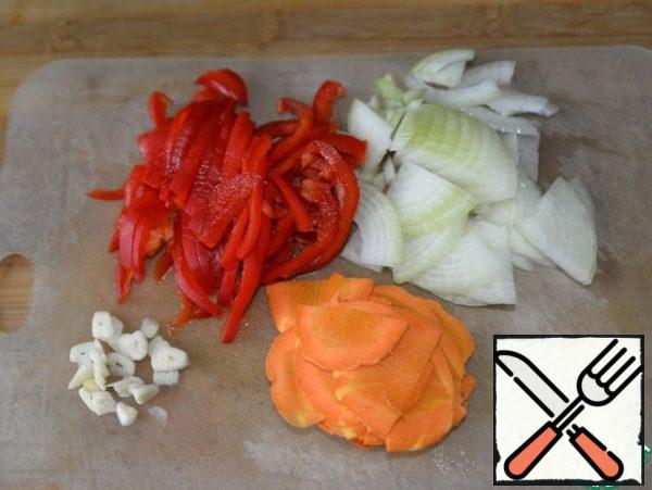 Vegetables are cleaned and washed. Onions are cut into thin half-rings or quarters, pepper strips, garlic slices, carrots in thin circles or halves.