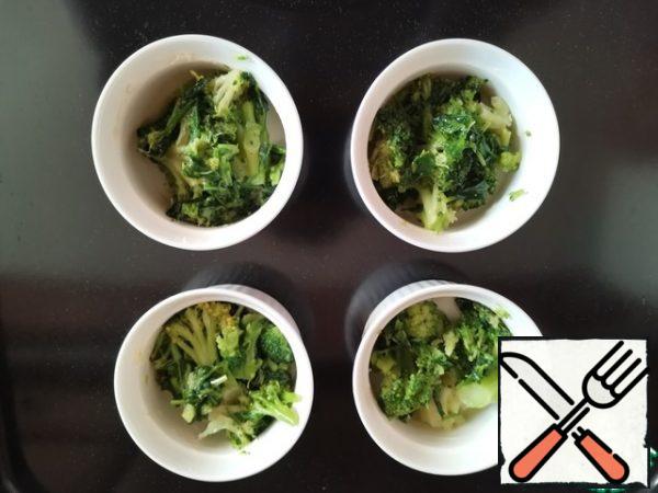 Preheat the oven to 150°C. Grease 4 200 ml baking pans with oil.
Break the broccoli into inflorescences, cut the stem into small pieces, and put it in molds.
