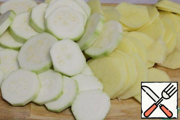 Peel the potatoes and zucchini and cut them into slices – thinner potatoes, thicker zucchini.
