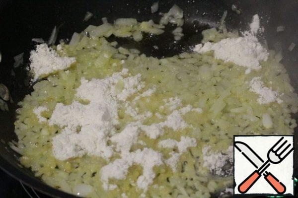 Add the flour to the onion and fry it, stirring.