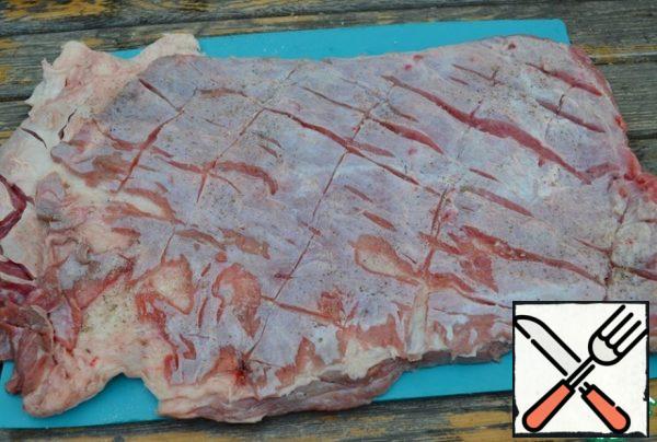 Wash the layer of beef flank, dry it, make incisions over the entire area with a sharp knife, add salt and pepper.
