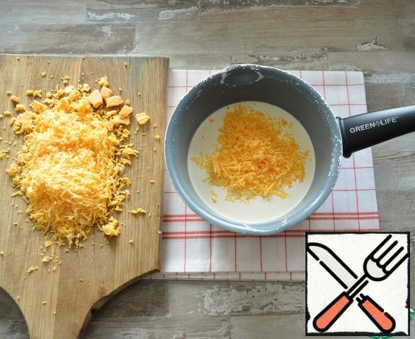 Meanwhile, prepare the cheese souffle.It is better to cook in non-stick dishes or in a water bath, as the mass may burn.
In 250 ml of fat (33%) cream, add grated cheese, heat while stirring, so that the cheese is completely dissolved in the cream.