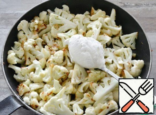 As soon as you realize that the cabbage is about ready and it has just 2-3 minutes left - add salt, sour cream, and mix. Cover and leave for 2-3 minutes.

The amount of sour cream is approximate, you can add more. Fat content is also to your taste, I had 20%.