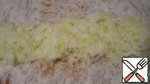Cut the cabbage into strips, add it, and cook with a little water until soft under the lid. Add the oil and salt and over high heat, stirring to remove excess moisture.Put the warm cabbage on a pita bread about 50*40 cm in size. Lavash pre - slightly moisten your hands with water, it will be easier to work with!