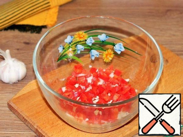 Red pepper is peeled from the seeds and tail and finely chopped. Add the pressed garlic.