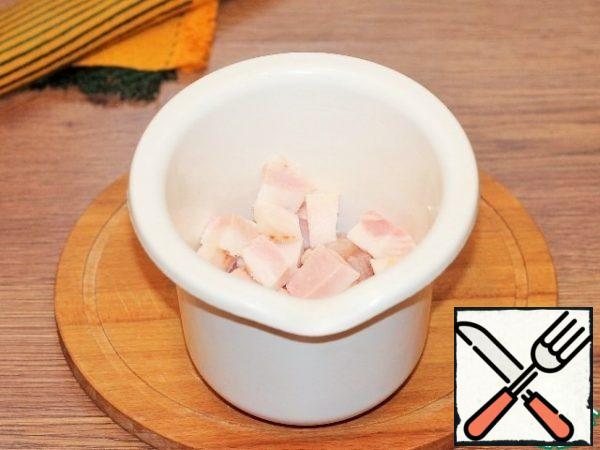 Put the pieces of Turkey fillet and sliced bacon in the bowl of a blender and chop.