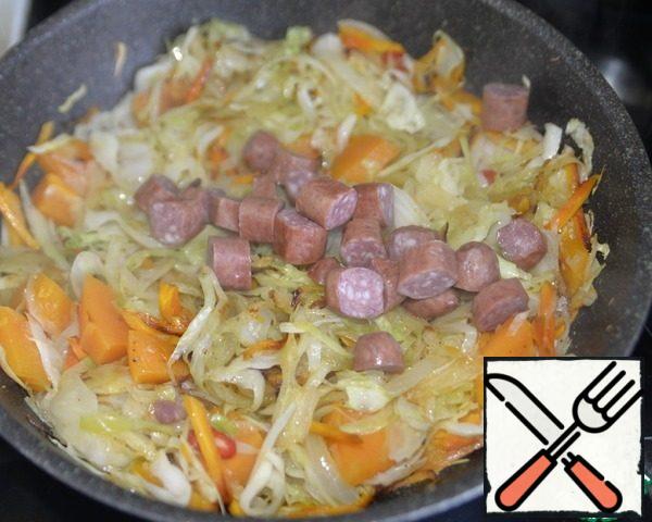 Put the chopped Hunting sausages, mix, and fry for 3 minutes. I'm at this stage slightly increase the heat to evaporate the excess liquid, but constantly interfere so that the vegetables do not burn.