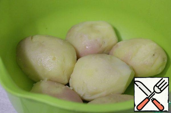 Boil the potatoes until ready in the "uniform", cool slightly and peel.