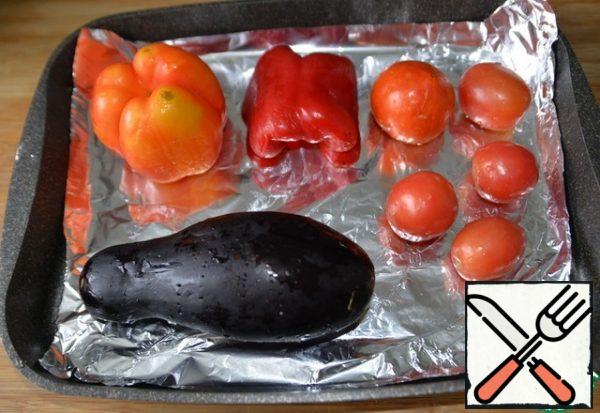 We take vegetables in a ratio of 1:1:1. Wash. Put foil on a baking sheet, eggplant, peppers, tomatoes on it. We pierce the eggplant with a fork several times. Put in the oven at 200 degrees for 40 minutes.
