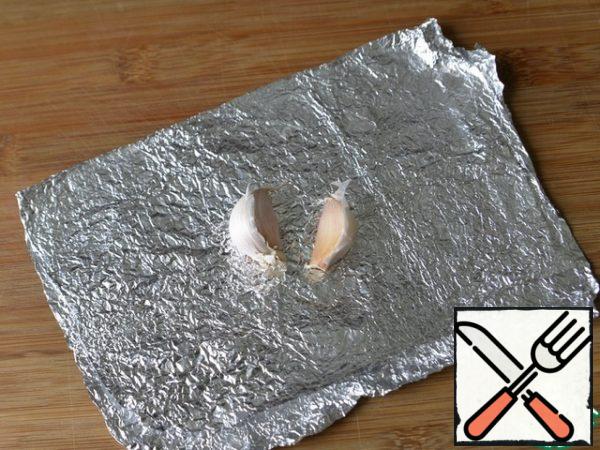 Wrap the garlic in foil and also put it in the oven to bake.
