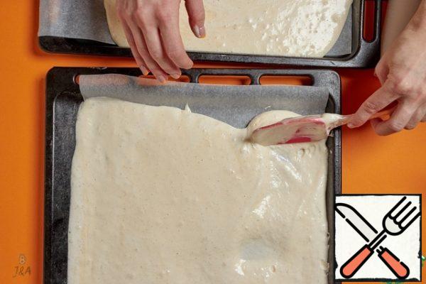 Cover two baking sheets with siliconized parchment, you do not need to lubricate anything. Distribute the dough.