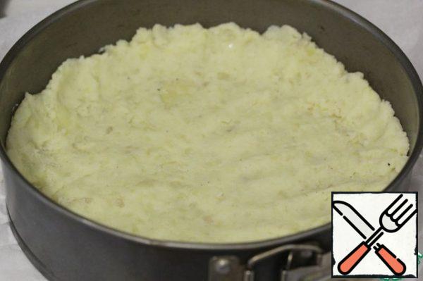 Cover the split baking dish (20-22 cm in diameter) with baking paper.
Divide the potato mass into unequal 2 parts: the one that is larger will go to the base, and the other to the top.
Form a base with small sides, lightly tamping most of the potatoes.