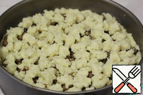 From the remaining potato mass, form small lumps and spread on top of the casserole.
Put the form in the oven, preheated to 180° C, and bake for about 35 minutes. If the surface of the casserole remains pale, you need to put it under the grill for a couple of minutes and brown it.