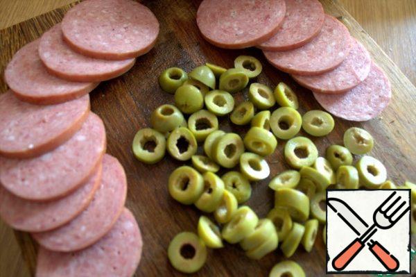 For the filling, cut any sausage (I have Servelat) and olives into rings.