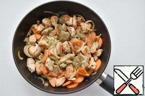 Add carrots and onions, salt, spices, add a small amount of sugar and fry the vegetables with meat for another couple of minutes.