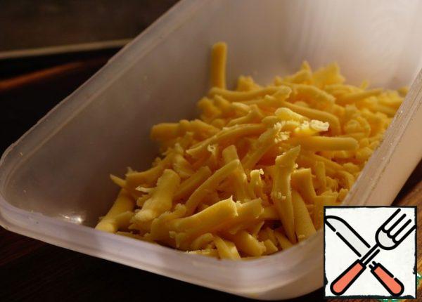 Grate the cheese on a coarse grater.