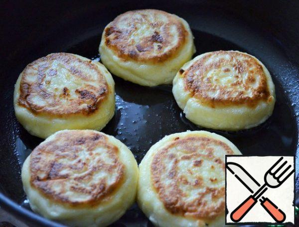 Preheat a frying pan with vegetable oil and 1 tablespoon of melted butter, fry the cheesecakes for 2 minutes on each side, medium heat.