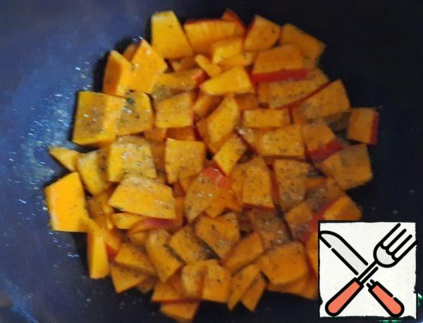 Grease the form with vegetable oil, put the pumpkin, sprinkle with dried herbs and garlic powder, put in a preheated oven for 15 minutes.