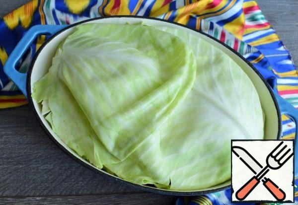 Wash the greens, dry them, and put them on the cabbage.
Cover tightly with cabbage leaves.