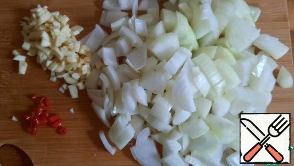 While the meat is being fried, add finely the onion, garlic and chili pepper.