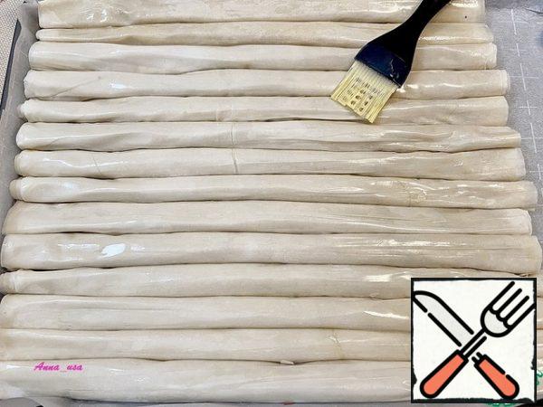 Cover the baking sheet with parchment. Put all the tubes tightly together. Thus filling the entire baking sheet. Brush with vegetable oil. Preheat the oven to 200*C. After 15-20 minutes of baking, when the cake is Golden, cover it with foil and continue baking for another 30 minutes.