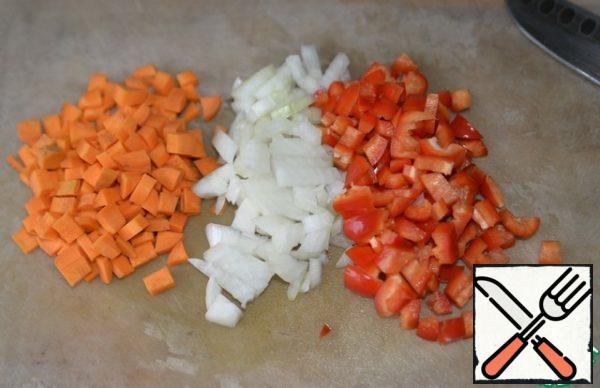 At the same time, we prepare the "roast". Vegetables: onions, red peppers and carrots are cleaned and cut into cubes.