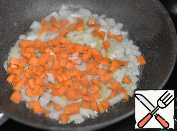 In vegetable oil in a frying pan, fry the onion over medium heat until transparent, add the carrots to it, fry for a couple of minutes.