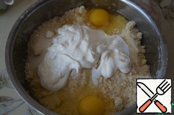 Add salt, sugar, eggs and sour cream to the butter and flour crumbs.