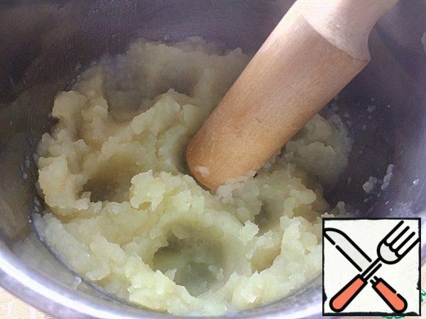 With the finished potatoes, drain almost all the water (drain it in a bowl so that you can add it to the mashed potatoes if necessary).
Mash the potatoes thoroughly.